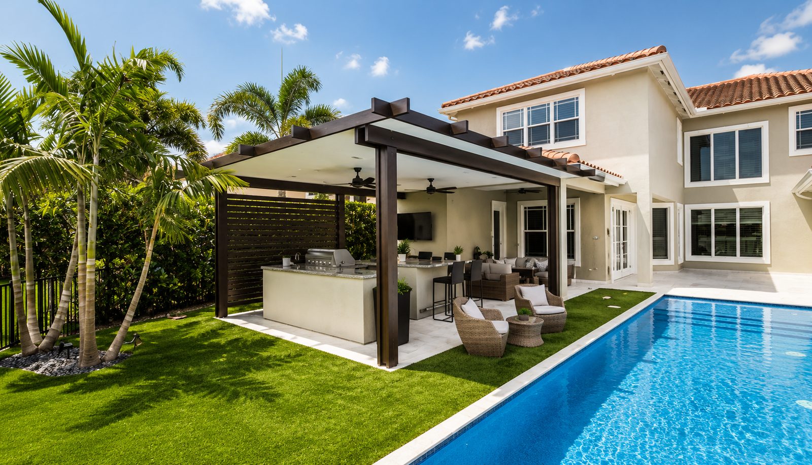 Bronze aluminum patio cover attached to a two-story home, shading an outdoor kitchen beside a pool