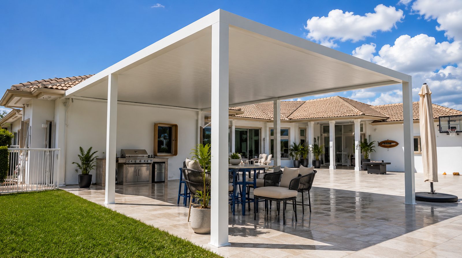 White aluminum patio cover attached to a tile-roof home over an outdoor dining and grill area